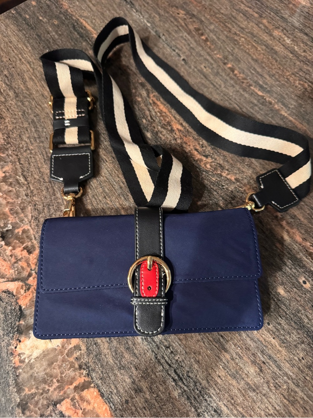 France’s ValentineNavy Crossbody Wallet with Striped Strap and Red Buckle Accent